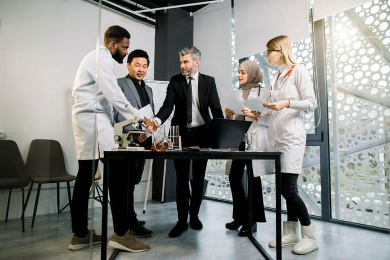 Interracial group of business men and doctors scientists team meeting in modern lab or office