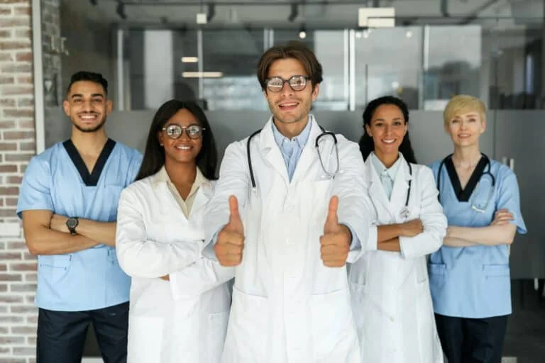 Multiethnic team of doctors posing together, smiling at camera